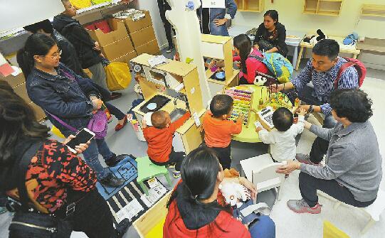 14日,家长带着孩子在儿童用品区玩耍。记者郭尧 摄