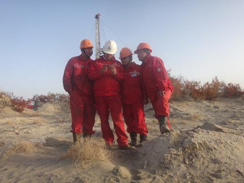 胜利油田井下西部中心侧钻6队员工在沙漠通过手机收看十九大开幕会直播。