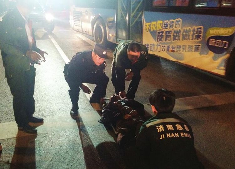 李源与120急救人员一起将男子抬上救护车。