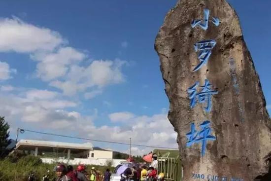 私家车在公路上排排堵,人群在田地边层层摞,红色小棚子也挤得密密麻麻....