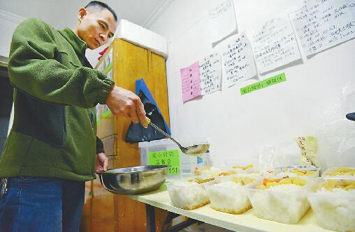 26日，在经五纬六路附近的“爱心厨房”，义务来帮忙的患儿家属盛午饭。