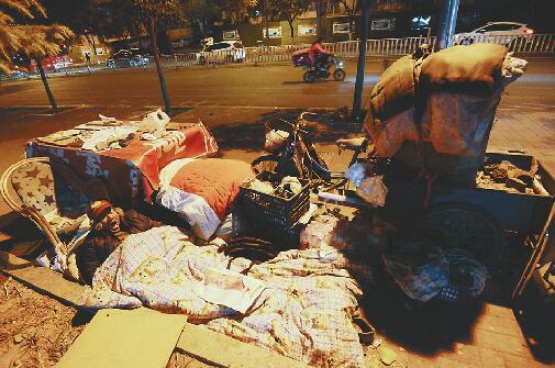 ①深夜11点,气温接近零摄氏度,老殷在路边搭起了被窝,钻进后打了一个呵欠。