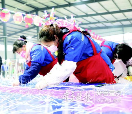 制作車間里,工人正往骨架上粘貼綢緞。
