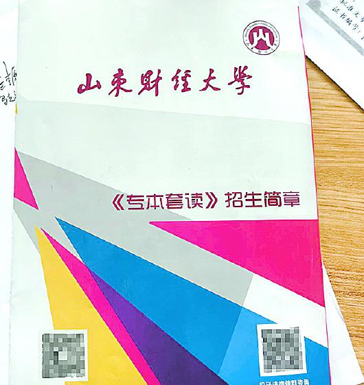 办公桌上摆着专本套读招生简章。 记者 袁野 吴永功 摄