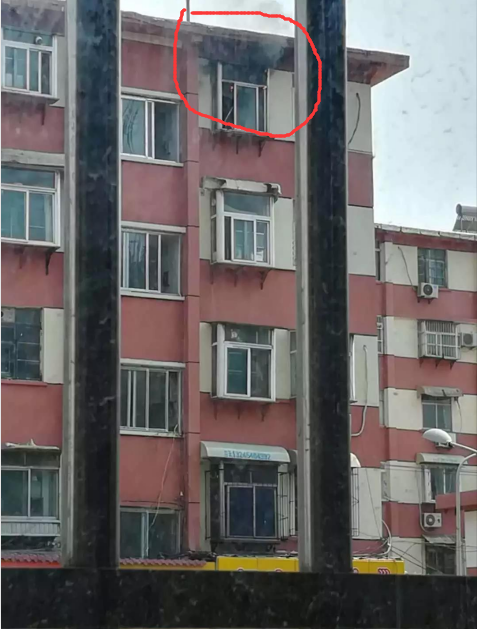 事发小区五楼着火住户家正冒浓烟。