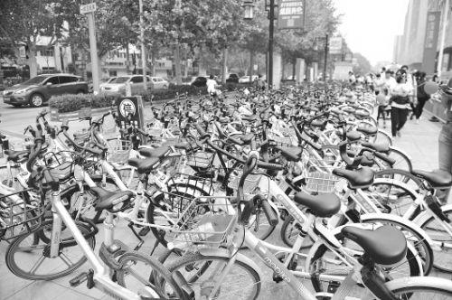 “五一"假期,泉城路上禁停区也停满了公共自行车,挤压了人行道。(资料片)