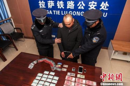 资料图:一犯罪嫌疑人对拉萨铁路警方查获的火车票进行指认。胡传鑫 摄