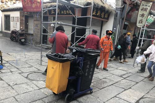 现在的芙蓉街上，由环卫工人手推流动垃圾桶来收集垃圾 记者 王颂博 摄