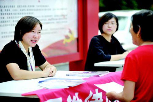 李卉正在社区里为居民们公益普法,一些有需要的居民向她咨询法律问题。