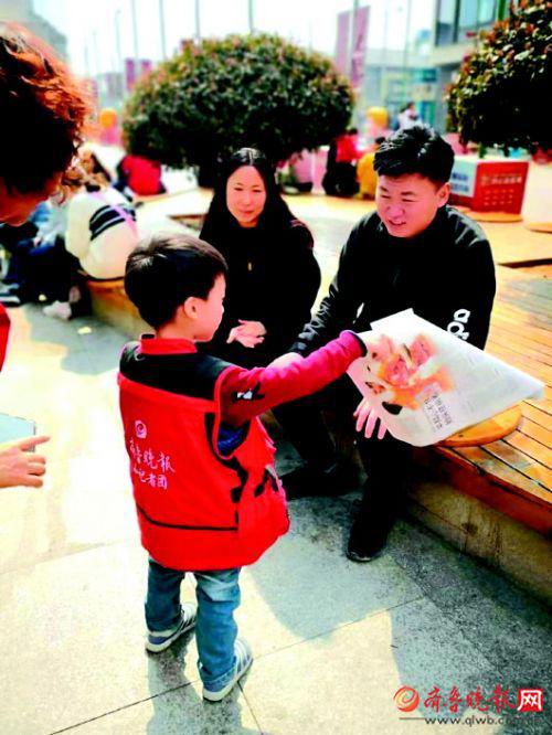 小志愿者走上街头义卖报纸。　　齐鲁晚报记者　林媛媛　摄