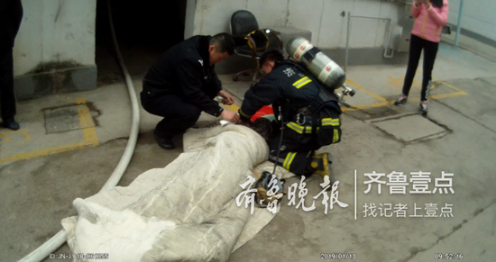 男子被救出后,民警和消防队员一起为伤者清洗鼻腔和口腔。