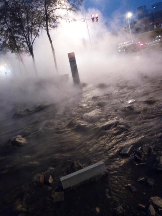 在蒸汽的笼罩下,事发地的能见度变低,经过该路段的车辆缓慢通行。