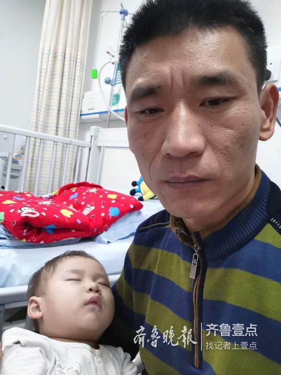 唐一軒躺在爸爸唐紹龍的懷里睡著了。