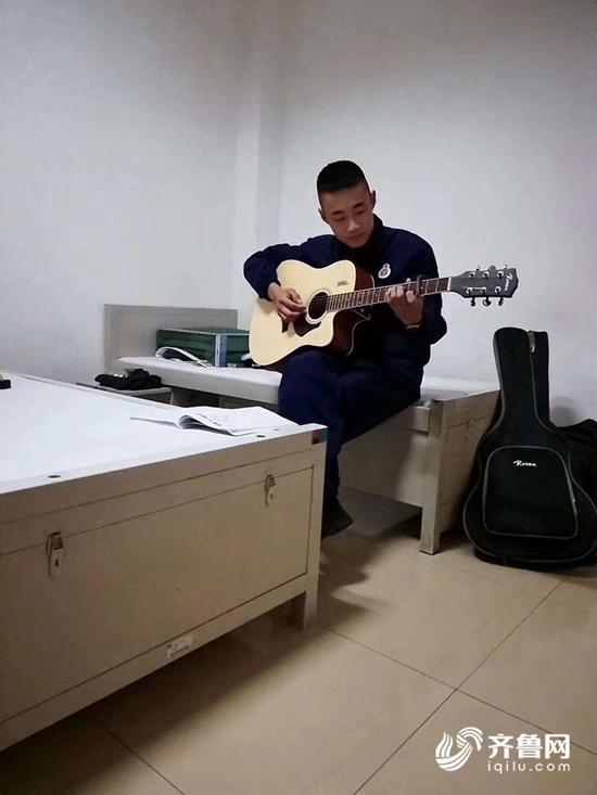 赵永一朋友圈截图，他在部队，跟着队长学会了弹吉他，这是他弹吉他的照片。