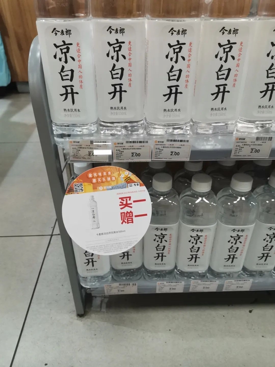 超市货架上,今麦郎凉白开挂着醒目的「买一赠一」标语 徐晴/摄