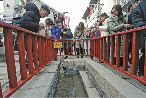 在芙蓉街中段，新发现的泉眼护栏上悬挂上了“新泉眼”的木牌。记者王锋摄