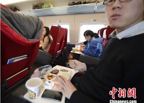 资料图：G801次列车一等座席的乘客在品尝列车提供的餐食。中新社发 侯宇 摄