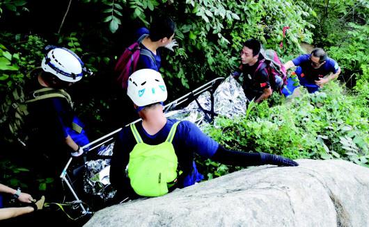 救援人员抬着出事驴友艰难下山。（救援队供图）