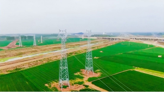 4月13日,在兖州区大安镇张家楼村,建设中的跨洸府河电网线路。(东海 摄)