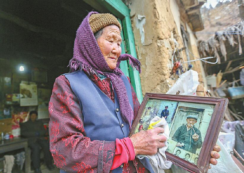 2017年11月29日，张永兰在弯弯地村10平方米的石头房子里擦拭老照片。