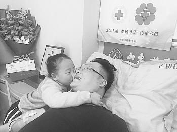 13日,許波在千佛山醫(yī)院捐獻造血干細胞。6歲的女兒許詩詩為爸爸加油。