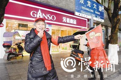 ▲紅綠燈前,費(fèi)婆婆嫻熟地拿出旗幟和口哨指揮行人安全過(guò)馬路。