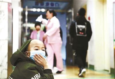 醫(yī)院內(nèi)沒(méi)有找到座位的小宇蹲在地上,等著爸爸為他排號(hào)抽血