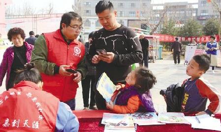 志愿者在高新區鳳凰社區免費發放防拐繪本(照片由采訪對象提供)。