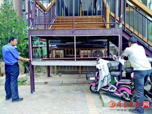 街道辦城管科和城管執(zhí)法中隊(duì)的工作人員一起測(cè)量違建的面積。