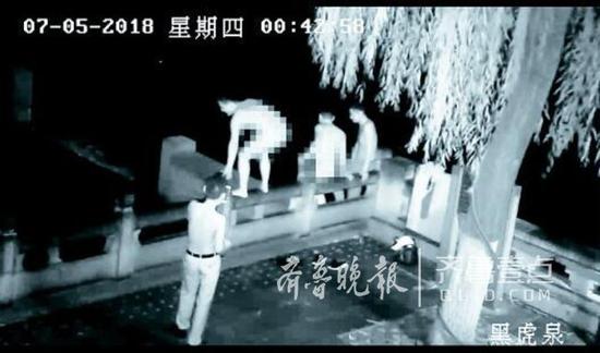 兩名男子脫光衣服準備跳入黑虎泉裸泳。視頻截圖
