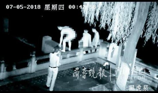 两名男子脱光衣服准备跳入黑虎泉裸泳。视频截图