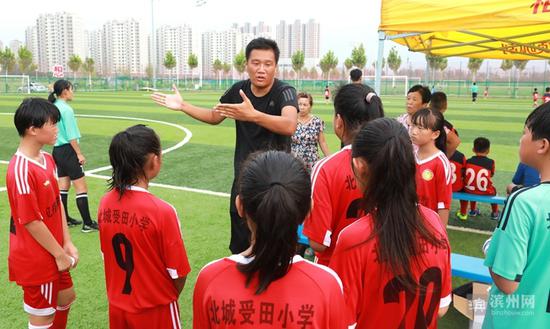 北城受田小学足球教练刘杨给球员们讲解战术。