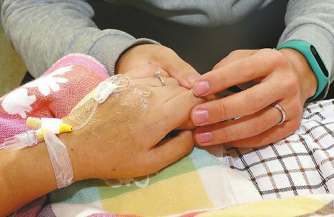 15日，在山东大学第二医院，刘兆柯紧紧握住女友薛雅伦的手。 记者王汗冰 摄