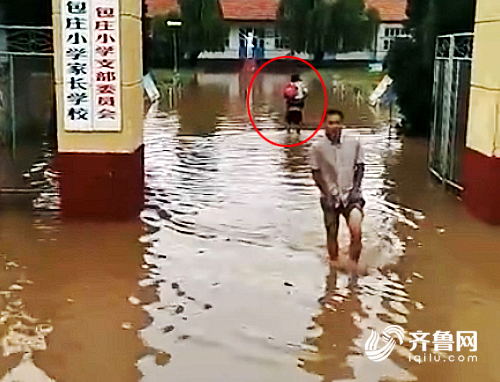 校門外,包莊小學的老師背著孩子進校園