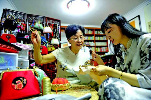 张慧正在和女儿一起制作手工,女儿对这门手艺的传承让她很欣慰。