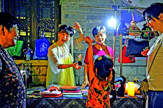 百花洲夜市上,張慧母女正在和喜愛手工制作的市民交流。