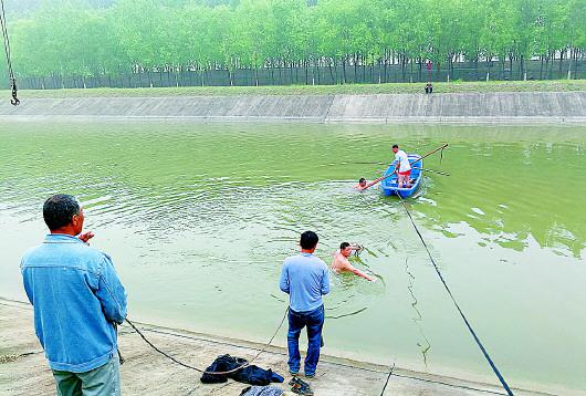 救援現場,赤膊的潛水員正將鉤子固定在水下的轎車上,而落水司機此時早已獲救