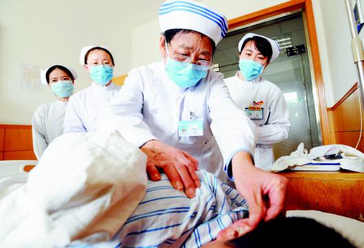 青岛六医78岁的李桂美护士长在护理病患，她是青岛仍在工作的最年长的护士。