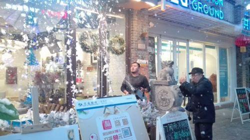 济南商家喷泡沫造雪景，卯足劲备战圣诞