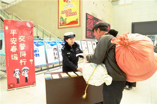春運(yùn)首日，淄博公安交警在客運(yùn)中心發(fā)放交通安全宣傳材料。