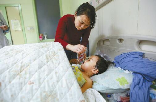 9日,在齐鲁儿童医院烧伤科病房,妈妈在喂小鑫萍吃饭。 记者刘玉乐 摄