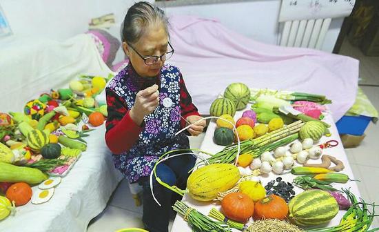 赵志纯的“果蔬”布艺作品摆满沙发和茶几