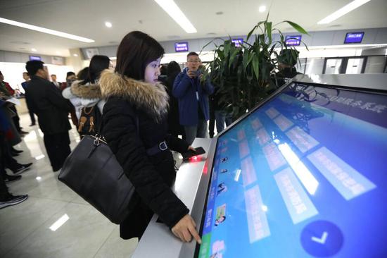 采访团记者体验济南市政务服务中心自助服务系统。