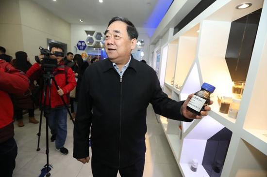 圣泉集团董事长唐一林向采访团介绍石墨烯原料。
