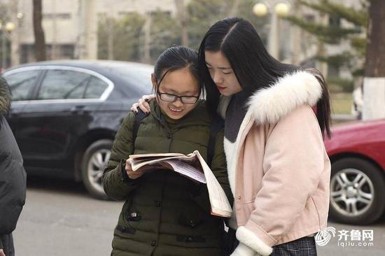 考试前，两名女生共同复习知识点。
