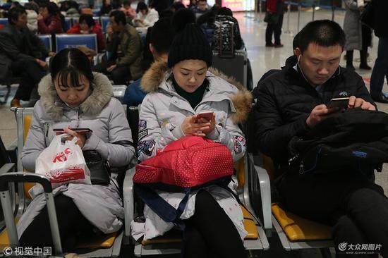济南:返乡人员聚集火车站 低头族成风景线