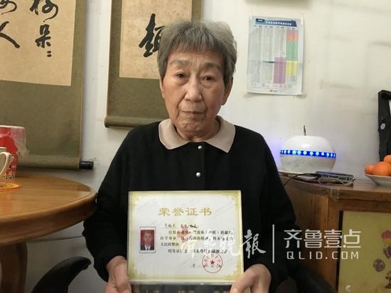 刘命华老人捧着老伴的遗体捐献荣誉证书。