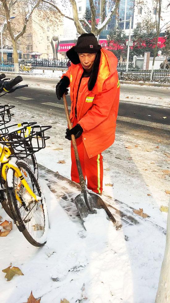 環(huán)衛(wèi)工人正在人民路上清掃積雪。