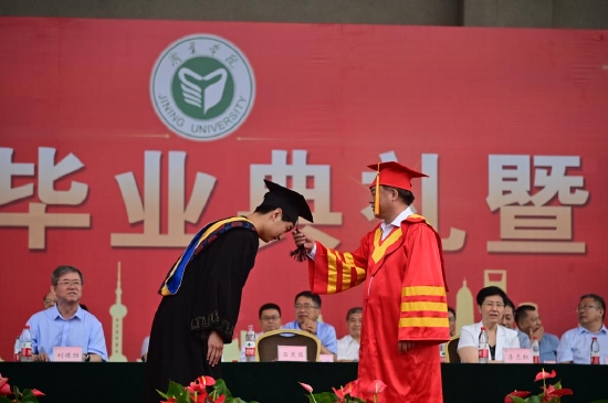 吕灵昌为获得学士学位的毕业生代表授以“拨穗礼”