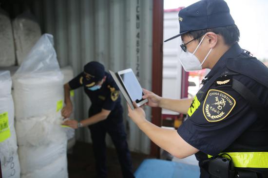 黄岛海关关员在对进口棉花进行查检（张进刚摄）